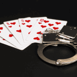 casino cards and handcuffs on a black table