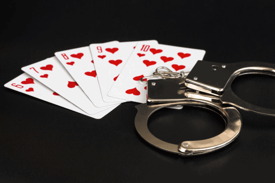 casino cards and handcuffs on a black table