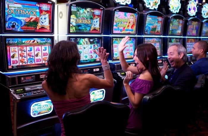two women cheering in front of slot machines