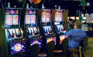 a woman sitting in front of slot machines 