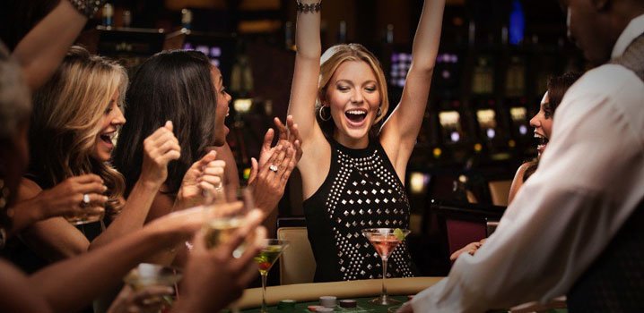 a girl cheering while sitting on a green casino table