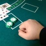 a hand laying on a blackjack table