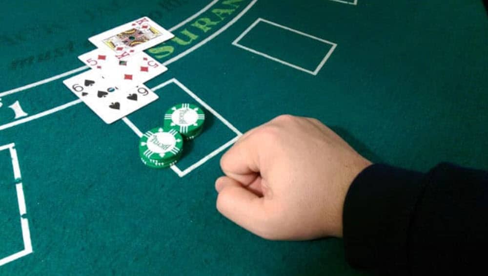 a hand laying on a blackjack table
